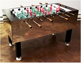 Oliver Clegg. One of the artist’s two custom-designed fooseball games, featuring nude figures of the artist (red) vs. his wife (green).